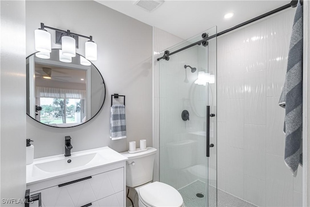 bathroom with ceiling fan, a shower with door, vanity, and toilet