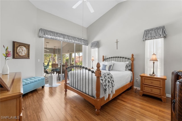 bedroom featuring hardwood / wood-style floors, access to outside, high vaulted ceiling, and ceiling fan