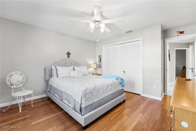 bedroom with hardwood / wood-style floors, a closet, and ceiling fan