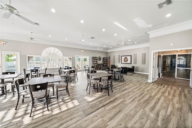 dining space featuring french doors, light wood-type flooring, ceiling fan, and crown molding