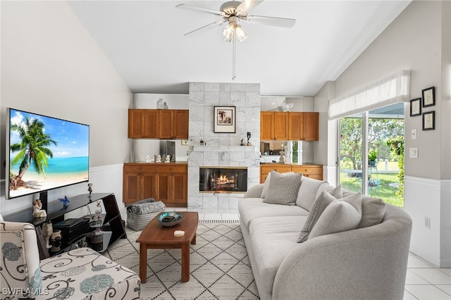 tiled living room featuring ceiling fan, a fireplace, and high vaulted ceiling