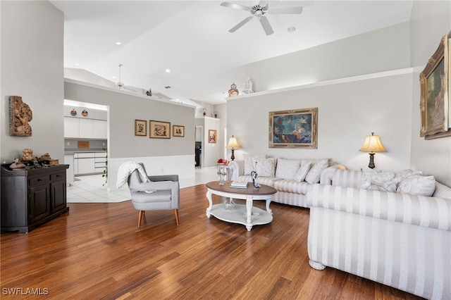 living room featuring hardwood / wood-style flooring, vaulted ceiling, and ceiling fan