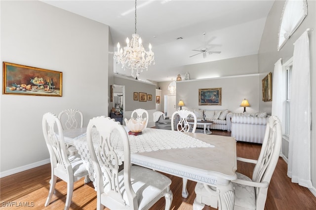 dining space with ceiling fan with notable chandelier, dark hardwood / wood-style flooring, and lofted ceiling