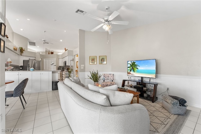 living room with light tile patterned floors, vaulted ceiling, and ceiling fan