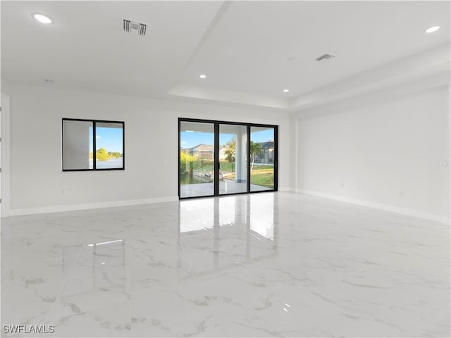 unfurnished room with a tray ceiling