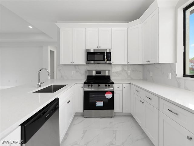 kitchen featuring white cabinetry, sink, appliances with stainless steel finishes, and tasteful backsplash