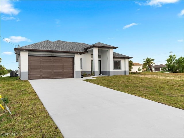 prairie-style house featuring a garage, central air condition unit, and a front lawn