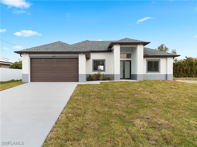 prairie-style house with a garage and a front lawn