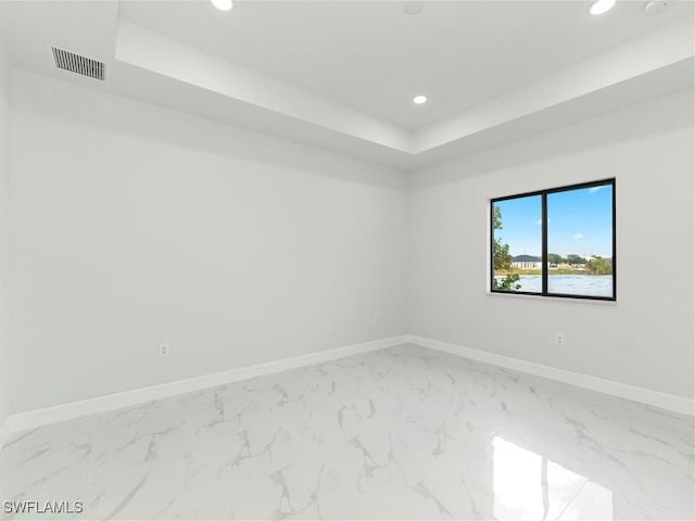 spare room featuring a tray ceiling