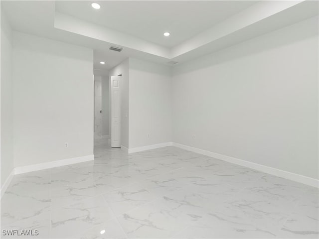 empty room featuring a tray ceiling