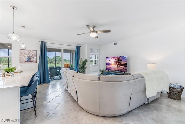 living room featuring light tile patterned floors, plenty of natural light, and ceiling fan