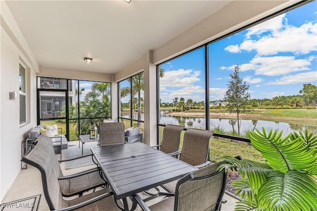 sunroom featuring a water view