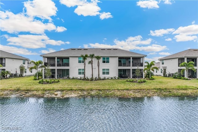 back of house featuring a yard and a water view