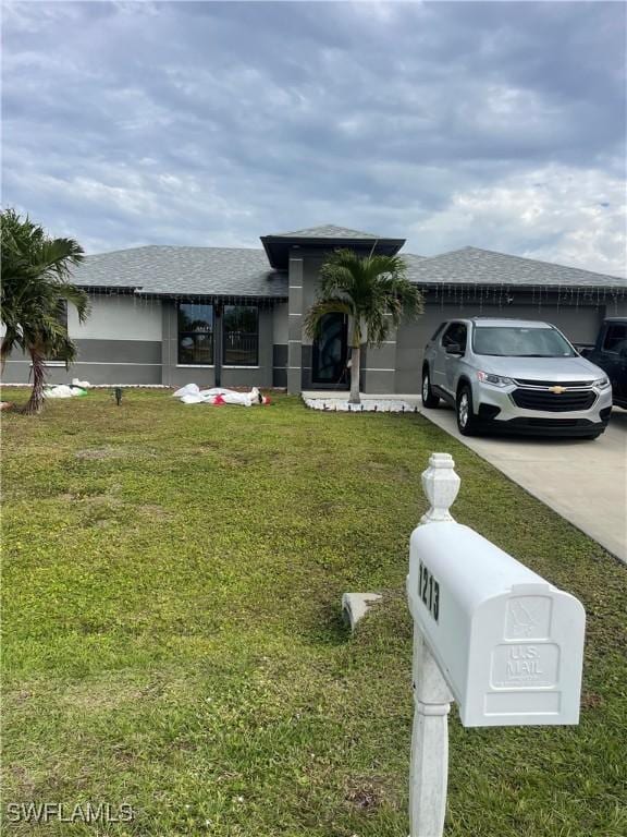 view of front of home featuring a front yard and a garage