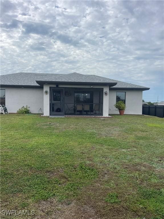 rear view of house with a sunroom and a yard