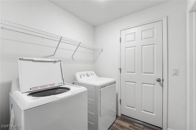 laundry area featuring washing machine and dryer and dark wood-type flooring