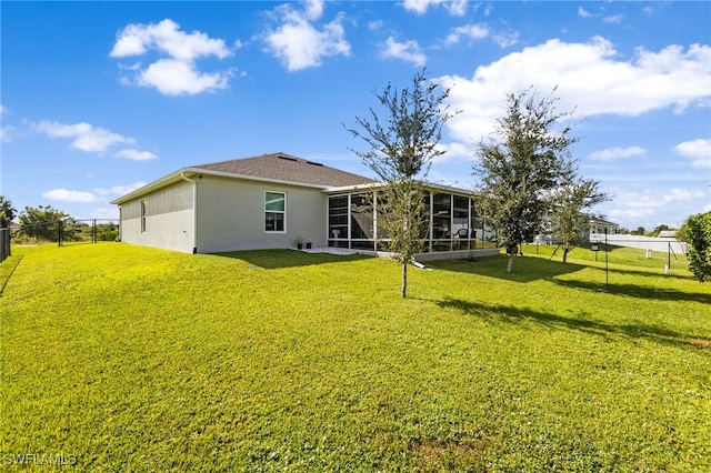 back of house featuring a lawn and a sunroom