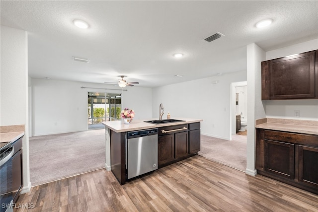 kitchen with sink, dark brown cabinetry, appliances with stainless steel finishes, and light colored carpet