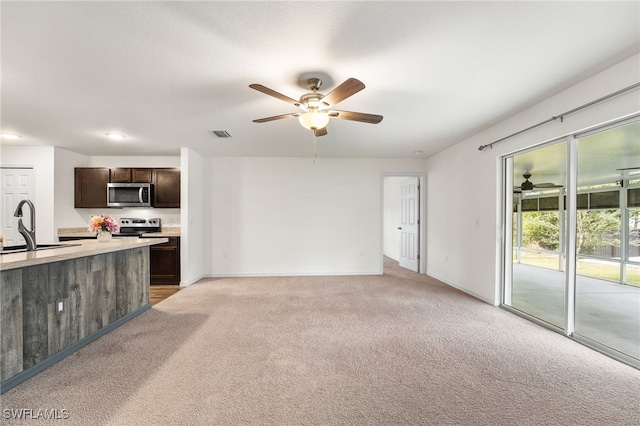 unfurnished living room with light colored carpet and sink