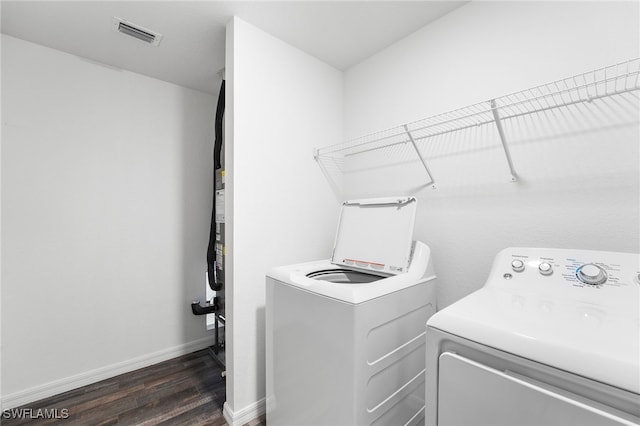 washroom with washer and dryer and dark wood-type flooring