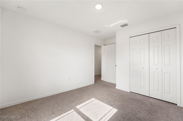 unfurnished bedroom featuring carpet and a closet