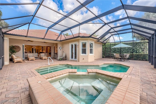 view of swimming pool with glass enclosure, an in ground hot tub, and a patio