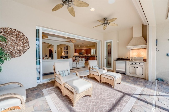 view of patio with area for grilling, ceiling fan, and exterior kitchen