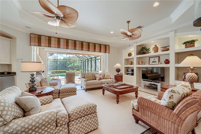 living room featuring built in features, light colored carpet, a raised ceiling, and crown molding