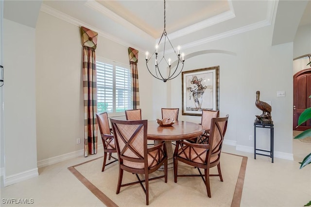 tiled dining space with a chandelier, a raised ceiling, and ornamental molding