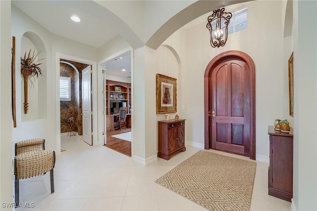 tiled entryway featuring a chandelier