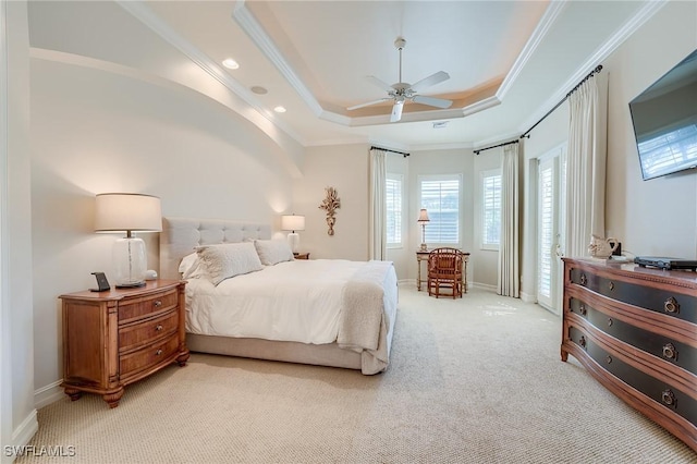 carpeted bedroom featuring a raised ceiling, ceiling fan, and crown molding