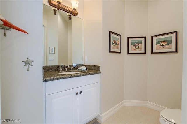 bathroom featuring tile patterned flooring, vanity, and toilet