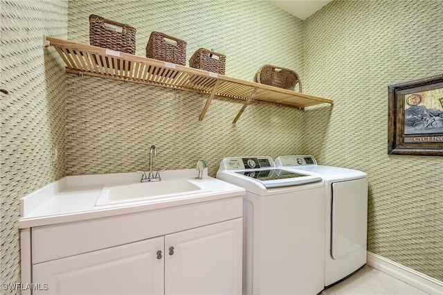 clothes washing area featuring separate washer and dryer, sink, light tile patterned flooring, and cabinets