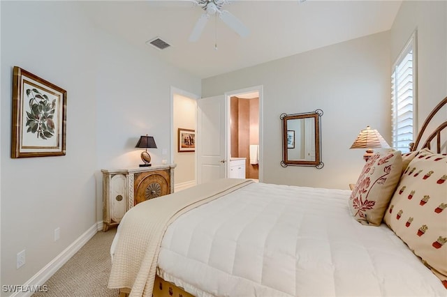 bedroom with ceiling fan, carpet floors, and ensuite bathroom