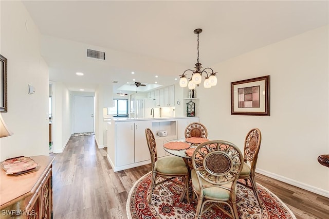 dining area with a chandelier and light wood-type flooring