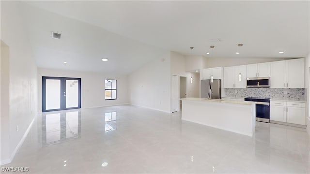 kitchen featuring stainless steel appliances, tasteful backsplash, pendant lighting, a center island with sink, and white cabinets