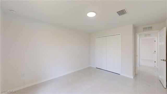 unfurnished bedroom with light tile patterned floors and a closet