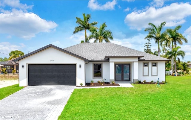 view of front of home featuring a front yard, french doors, and a garage