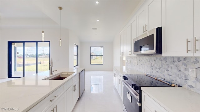 kitchen featuring appliances with stainless steel finishes, decorative light fixtures, sink, white cabinets, and light stone counters