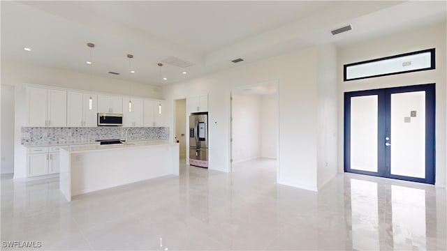 kitchen featuring appliances with stainless steel finishes, a center island with sink, white cabinets, and french doors