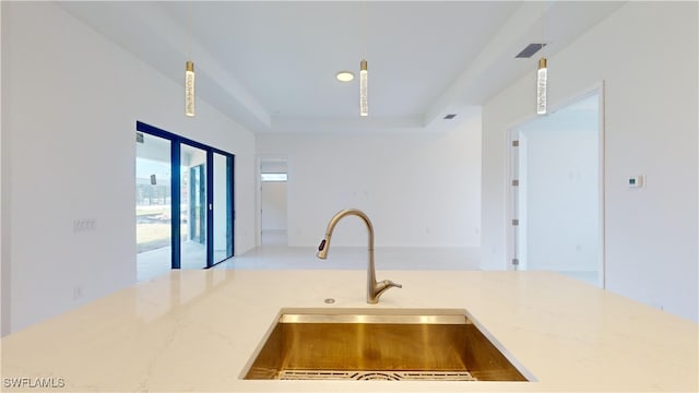 kitchen featuring a tray ceiling and sink