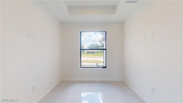 empty room featuring a raised ceiling