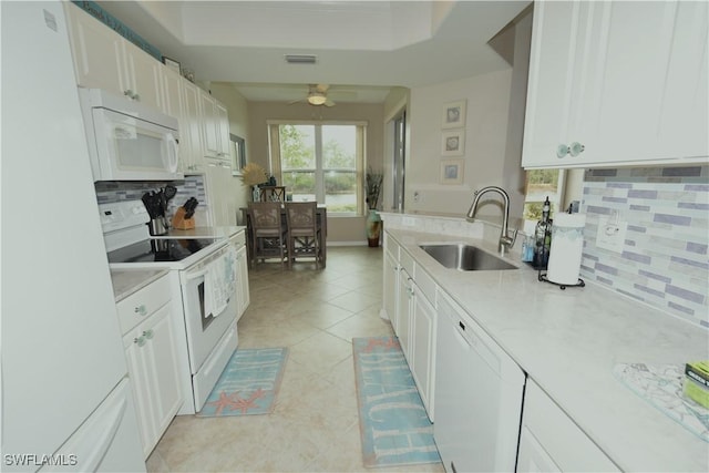 kitchen featuring white cabinetry, sink, backsplash, white appliances, and light tile patterned floors