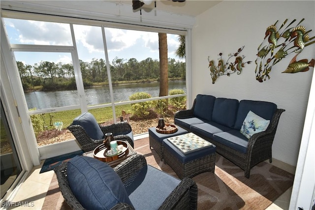 sunroom featuring ceiling fan and a water view