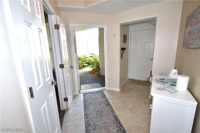 doorway to outside with light tile patterned floors