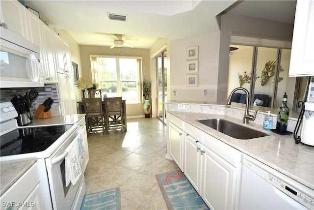 kitchen featuring white appliances, sink, ceiling fan, light tile patterned flooring, and white cabinetry