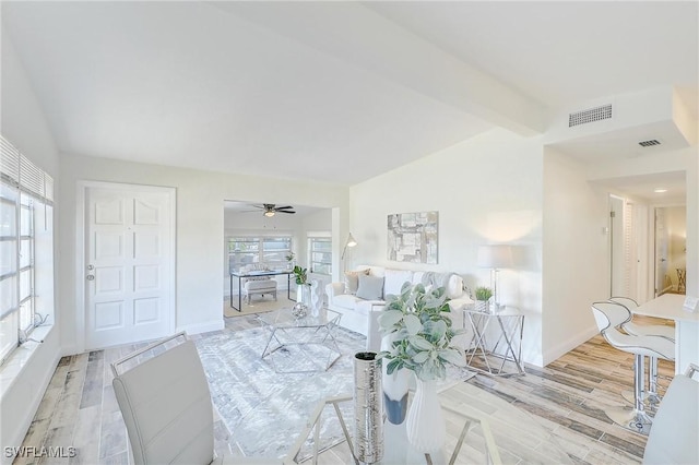 living room with vaulted ceiling with beams, ceiling fan, and light hardwood / wood-style flooring