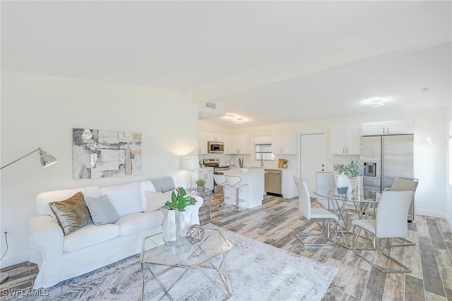 living room featuring light hardwood / wood-style floors and vaulted ceiling