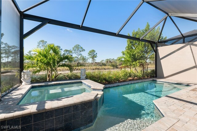 view of swimming pool with a lanai, a patio area, and an in ground hot tub