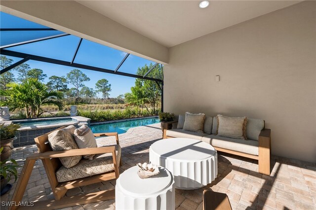 view of patio / terrace featuring an outdoor living space and glass enclosure